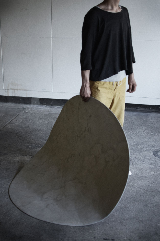 モルタル製のフロアマットを片手で持ち上げる